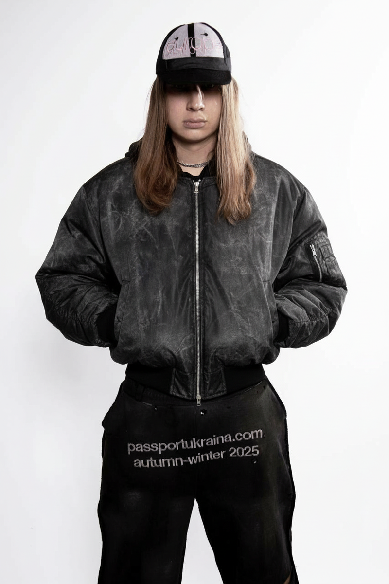 Модель в чорному бомбері з контрастною текстурою